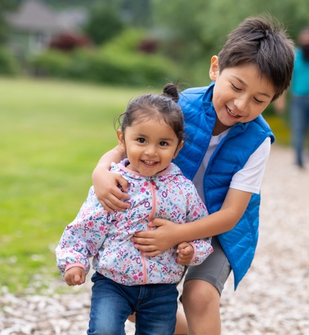 Two smiling toddlers in park