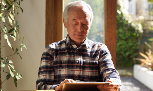 man sitting and working on tablet